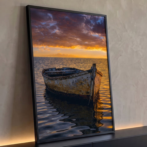 Quadro Decorativo Grande Barco Antigo para Sala Laranja | quadros decorativos para sala | barco de madeira desgastado flutuando em mar calmo sob céu de pôr do sol laranja e roxo | Porao dos Quadros