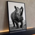 Rinoceronte caminhando de frente com chifres em destaque, fotografia preto e branco, quadro decorativo