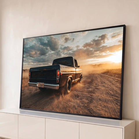 Picape Ford antiga preta levantando poeira em estrada de terra ao pôr do sol dourado, quadro decorativo