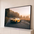 Lamborghini amarela em estrada de montanha com pinheiros e névoa dourada ao pôr do sol, quadro decorativo