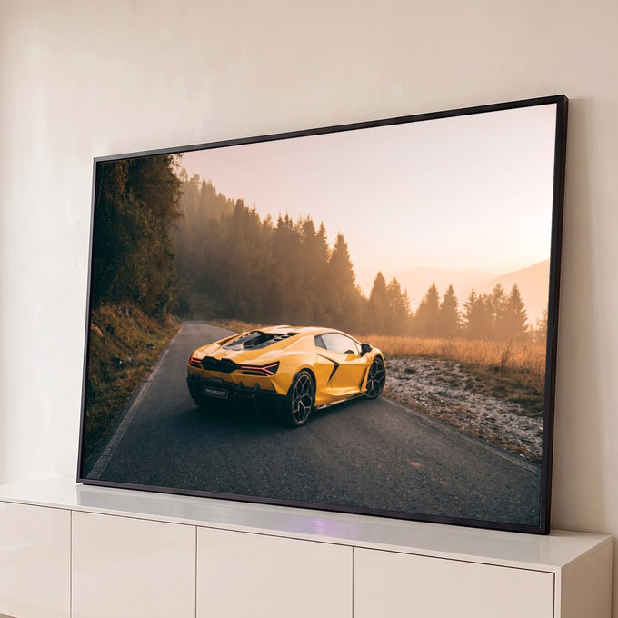 Lamborghini amarela em estrada de montanha com pinheiros e névoa dourada ao pôr do sol, quadro decorativo