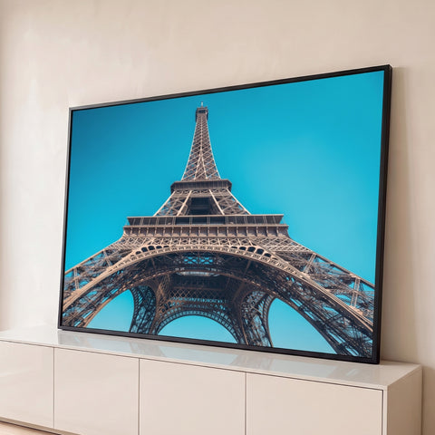 Torre Eiffel vista de baixo com arcos de ferro e céu azul-turquesa em Paris, quadro decorativo