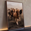 Manada de cavalos islandeses galopando na areia negra com poeira e montanha ao fundo, quadro decorativo