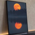 Lua cheia laranja sobre silhueta de pinheiros refletida em lago enevoado ao anoitecer, quadro decorativo