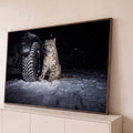Quadro Decorativo Grande Leopardo das Neves Neve para Sala | quadros decorativos para sala | leopardo-das-neves sentado na neve ao lado de pneu de carro à noite | Porao dos Quadros