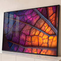Fotografia macro de folha em contraluz com nervuras em degradê roxo, rosa e laranja, quadro decorativo