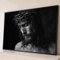 Jesus de cabeça baixa com coroa de espinhos, em fotografia preto e branco sobre fundo escuro, quadro decorativo