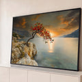 Árvore de frutos vermelhos sobre rochedo à beira-mar com pôr do sol laranja e montanhas, quadro decorativo