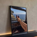 Pernas de mulher com scarpin vinho no painel de conversível vintage com vista para o mar, quadro decorativo