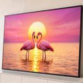 Dois flamingos rosa formando um coração diante do sol dourado refletido na água, quadro decorativo