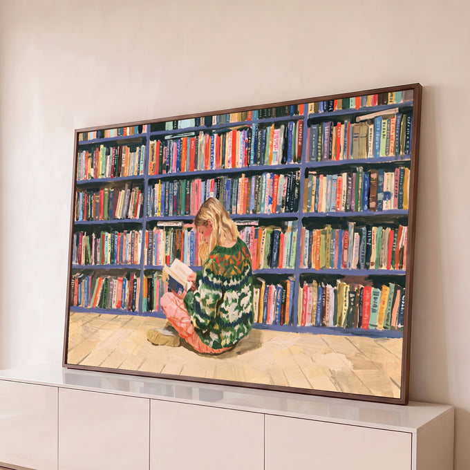 Quadro Decorativo Grande Mulher Lendo Verde para Sala | quadros decorativos para sala | mulher loira sentada lendo livro diante de estante colorida de livros | Porao dos Quadros