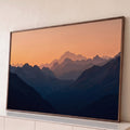 Quadro Decorativo Grande Cordilheira em Camadas para Sala | quadros decorativos para sala | cordilheira em camadas azuis sob céu laranja ao entardecer com pico nevado ao fundo | Porao dos Quadros