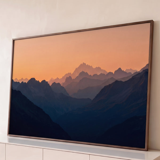 Quadro Decorativo Grande Cordilheira em Camadas para Sala | quadros decorativos para sala | cordilheira em camadas azuis sob céu laranja ao entardecer com pico nevado ao fundo | Porao dos Quadros