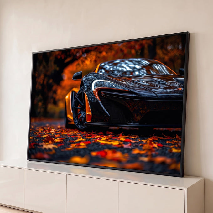Supercarro preto com detalhes laranja sobre estrada coberta de folhas de outono, quadro decorativo