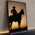 Silhueta de peão de chapéu montado a cavalo contra céu laranja de pôr do sol, quadro decorativo