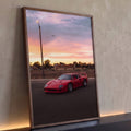 Ferrari F40 vermelha estacionada sob céu rosa do pôr do sol com avião ao fundo, quadro decorativo
