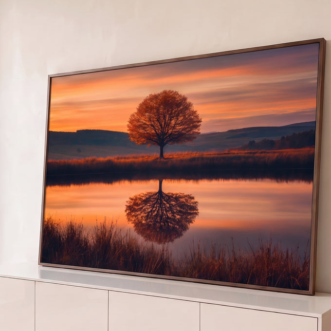 Árvore de outono solitária refletida em lago calmo sob céu laranja de pôr do sol, quadro decorativo