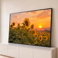Campo de girassóis em primeiro plano com sol se pondo no horizonte e céu laranja, quadro decorativo