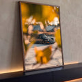 Quadro Decorativo Grande Carro Preto para Sala Cinza | quadros decorativos para sala | carro esportivo cinza escuro visto através de folhas amarelas ao pôr do sol | Porao dos Quadros