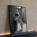 Menino oferece sorvete a menina em ruela de pedra com arco antigo, foto preto e branco, quadro decorativo