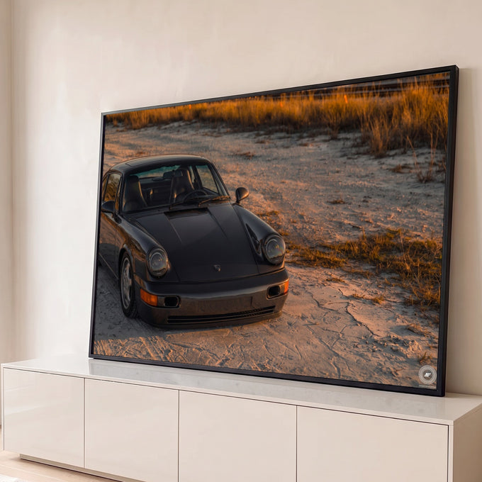 Quadro Decorativo Grande Carro Esportivo Praia para Sala | quadros decorativos para sala | carro esportivo cinza-escuro em dunas de areia sob luz dourada de pôr do sol | Porao dos Quadros