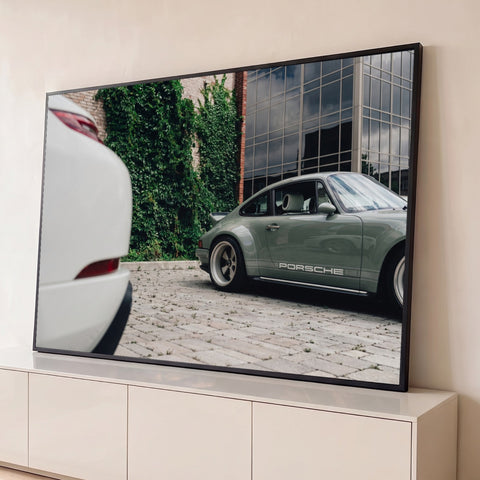 Porsche 911 clássico verde-sálvia com rodas vintage diante de parede com hera e prédio de vidro, quadro decorativo
