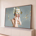 Mulher com flores brancas cobrindo o rosto, fitas e flocos dourados sobre fundo cinza, quadro decorativo