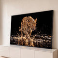 Leopardo cravejado de cristais caminhando na água com respingos dourados e fundo preto, quadro decorativo