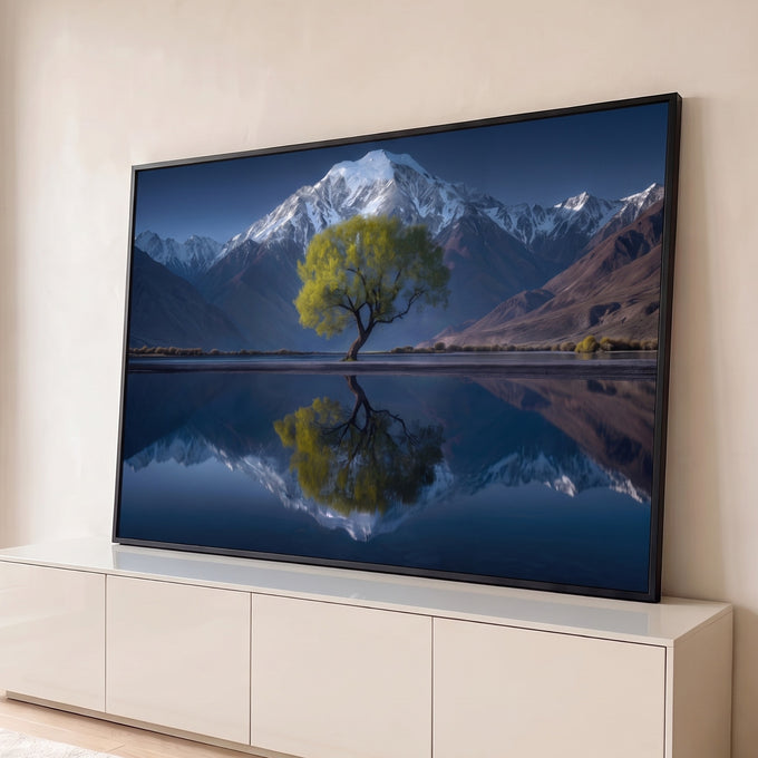 Árvore verde diante de montanha nevada refletida em lago espelhado sob céu azul, quadro decorativo