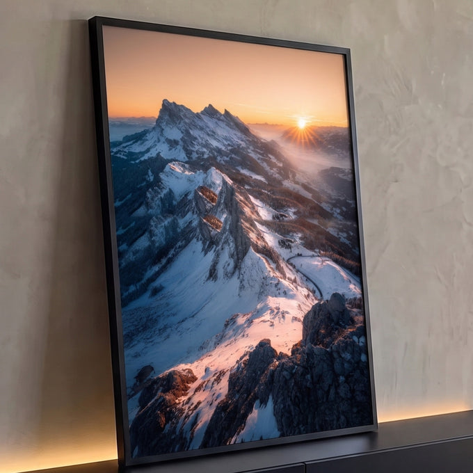 Picos nevados dos Alpes com sol nascendo no céu laranja e névoa no vale, quadro decorativo