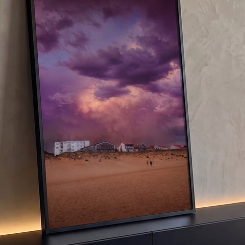 Praia com dunas, casas e nuvens de tempestade roxas e rosadas no céu, quadro decorativo