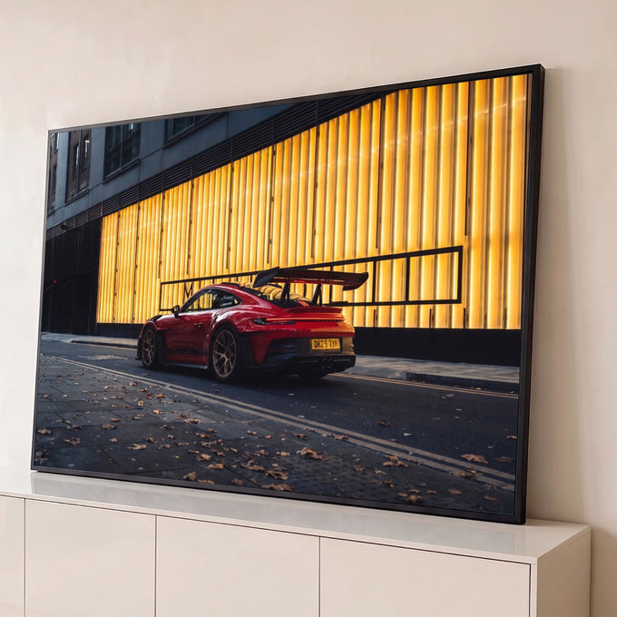Porsche 911 GT3 vermelho com aerofólio em rua urbana diante de painéis dourados iluminados, quadro decorativo