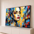 Rosto de mulher craquelado com lábios vermelhos, respingos amarelos e prédios ao fundo, quadro decorativo