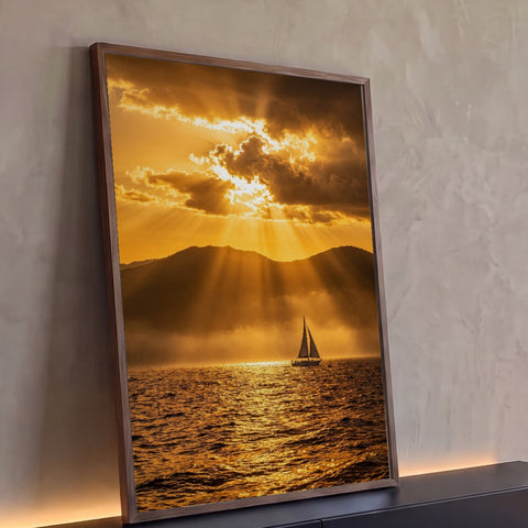 Quadro Decorativo Grande Veleiro ao Entardecer para Sala | quadros decorativos para sala | veleiro no mar dourado sob raios de sol entre nuvens e montanhas ao entardecer | Porao dos Quadros