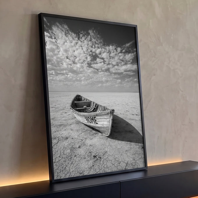 Barco de madeira escrito HOME em terra rachada sob céu com nuvens, preto e branco, quadro decorativo