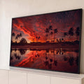 Quadro Decorativo Grande Palmeiras e Céu para Sala Vermelho | quadros decorativos para sala | silhuetas de palmeiras contra céu vermelho intenso refletido na água de uma praia | Porao dos Quadros