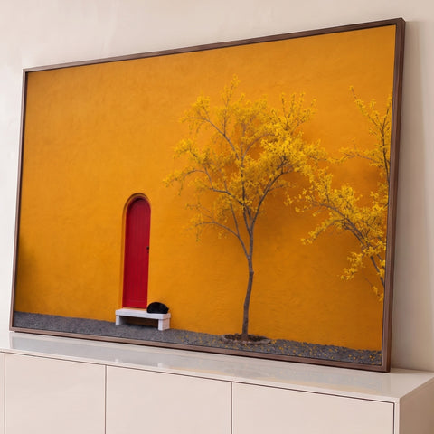 Fachada laranja com porta vermelha em arco, gato preto no banco e ipê amarelo, quadro decorativo