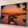 Quadro Decorativo Grande Píer ao Pôr do Sol para Sala | quadros decorativos para sala | píer de madeira com bicicleta e lampiões acesos ao pôr do sol laranja | Porao dos Quadros