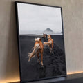Cavalos de crina loira trotando em praia de areia preta rumo à montanha na neblina, quadro decorativo