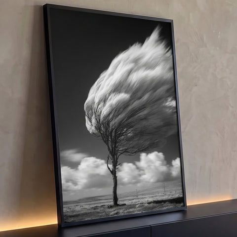 Árvore solitária com copa desfocada pelo vento, nuvens e céu escuro em preto e branco, quadro decorativo