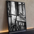 Pássaro pousado no guidão de bicicleta antiga com placa Fly em foto preto e branco, quadro decorativo