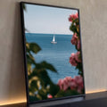 Quadro Decorativo Veleiro no Mar Emoldurado por Flores Rosa | quadros decorativos para sala | veleiro branco no mar azul visto entre flores rosa desfocadas em primeiro plano | Porao dos Quadros