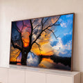 Quadro Decorativo Grande Árvore Seca Laranja para Sala | quadros decorativos para sala | árvore seca em silhueta contra céu dividido entre pôr do sol, lua e nuvens azuis | Porao dos Quadros