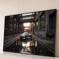 Corvette clássico prata em beco industrial de tijolos com reflexo na água ao pôr do sol, quadro decorativo
