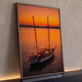 Veleiro com luzes e pessoas no convés navegando em mar calmo sob pôr do sol laranja, quadro decorativo