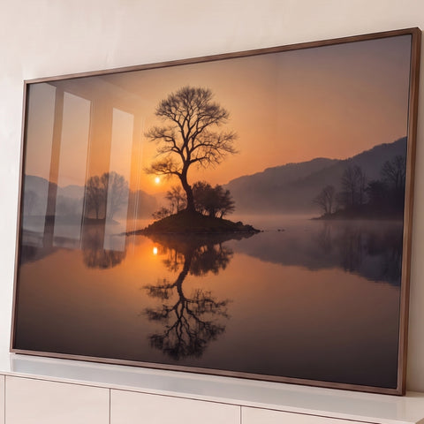 Árvore seca em pequena ilha no lago com névoa, sol laranja e reflexo na água, quadro decorativo
