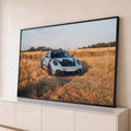 Porsche 911 GT3 RS azul-claro com aerofólio em campo de grama dourada ao pôr do sol, quadro decorativo