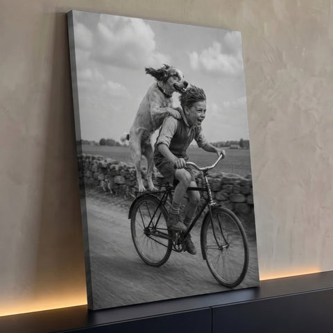 Menino rindo de bicicleta com cachorro em pé na garupa em estrada rural, preto e branco, quadro decorativo