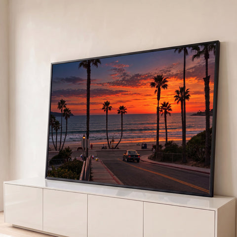 Pôr do sol laranja na praia com palmeiras, oceano e carro clássico na estrada da orla, quadro decorativo