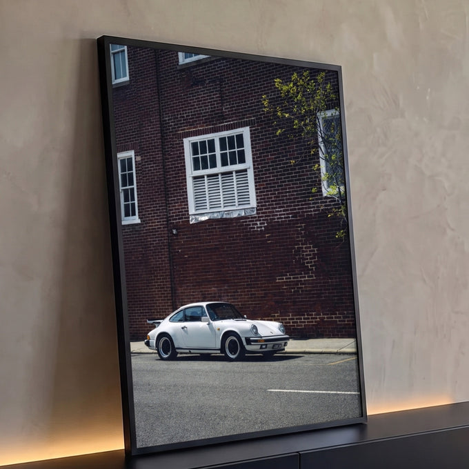 Quadro Decorativo Grande Carro Clássico Branco para Sala | quadros decorativos para sala | carro esportivo branco clássico estacionado em rua com parede de tijolos ao fundo | Porao dos Quadros